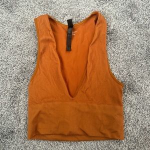 Urban Outfitters out from under orange top